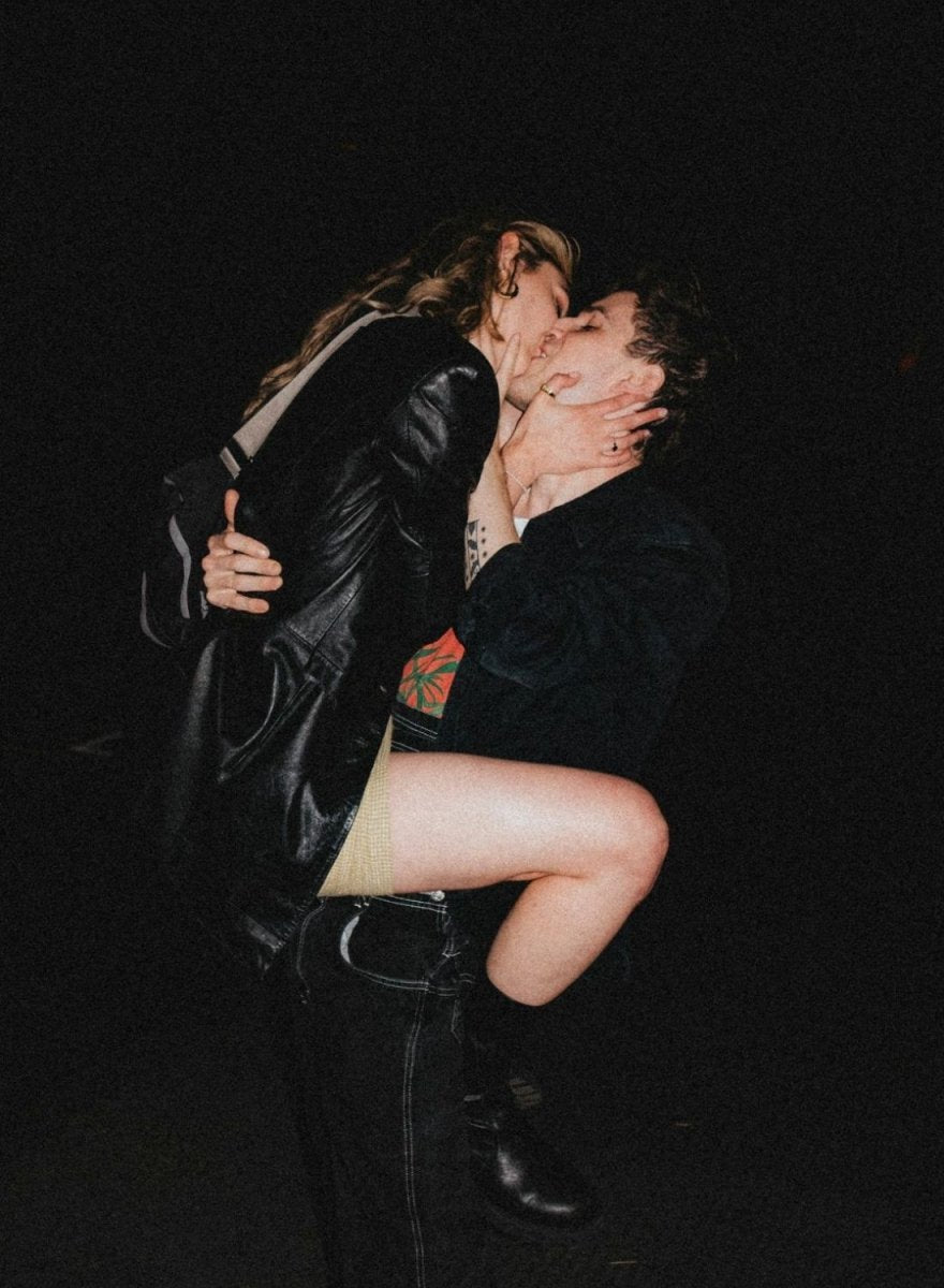 Paar küsst sich in einer dunklen Umgebung, der Moment wirkt leidenschaftlich und spontan